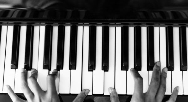 Fingers on a piano keyboard