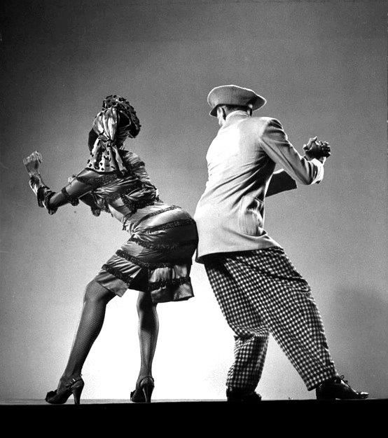 A man dancing with a woman bumping his bum to hers