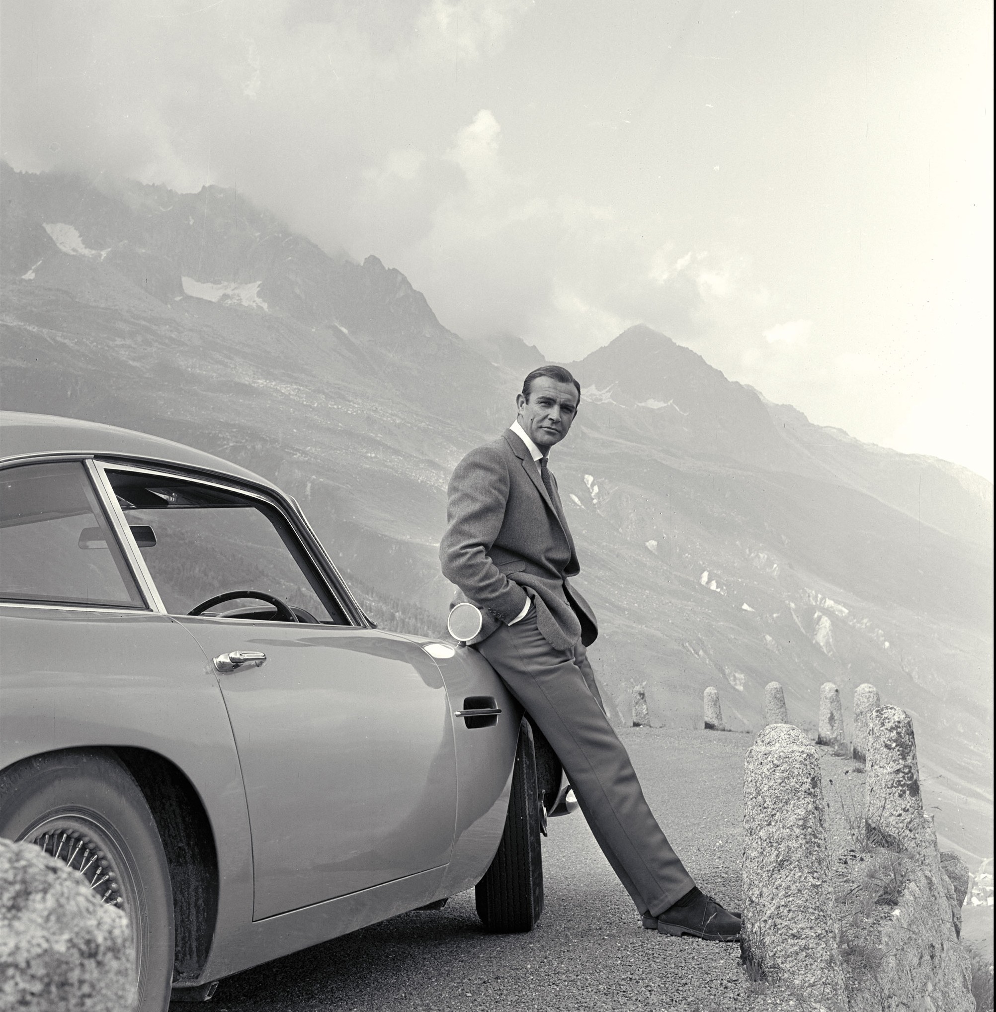 Sean Connery as James Bond, leaning on his car