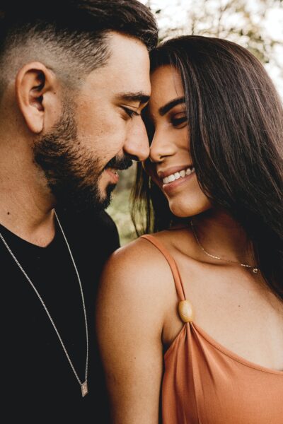 A latin man and latin woman touching their foreheads together and smiling 