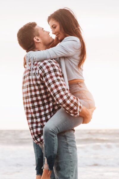 A man lifting a woman looking into her eyes 