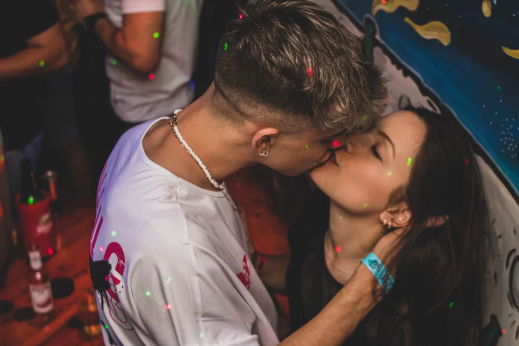 A man kissing a girl at a bar