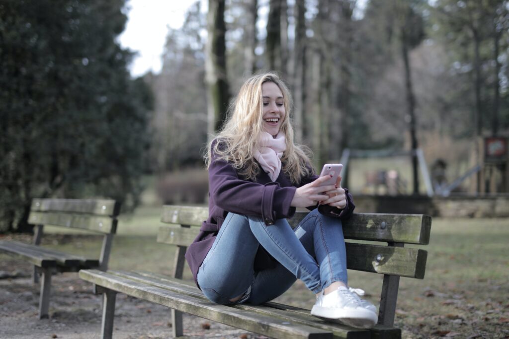 a woman on a park bench texting 
