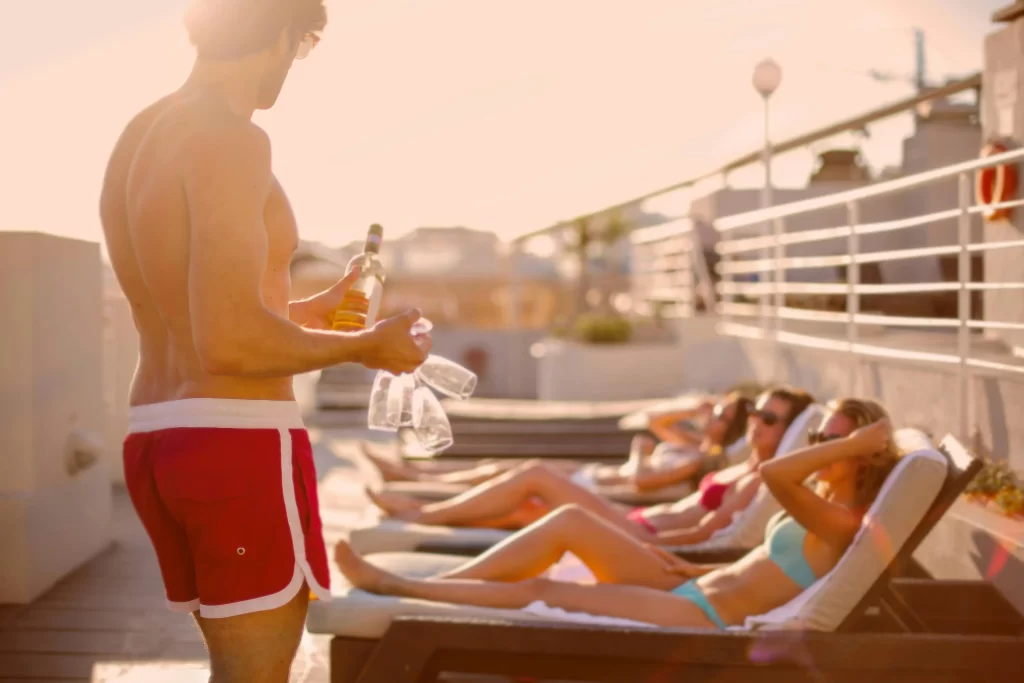 Shirtless man approaching women at the pool