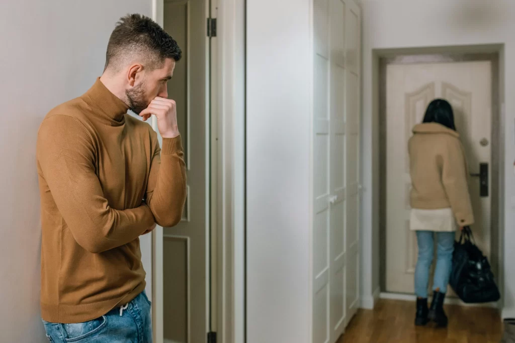 Man looking at his crying girlfriend in an apartment